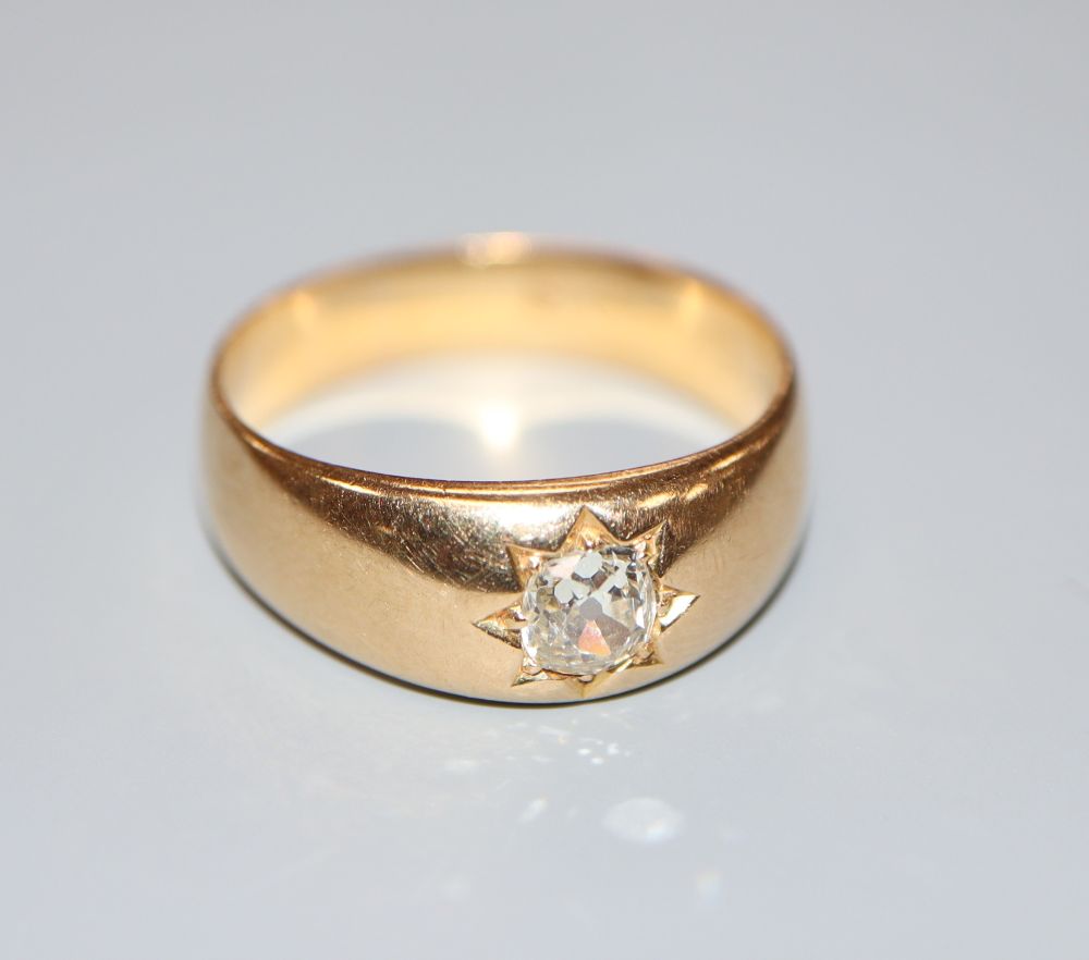 A late Victorian yellow metal and gypsy set solitaire diamond ring, size R, gross 7 grams.
